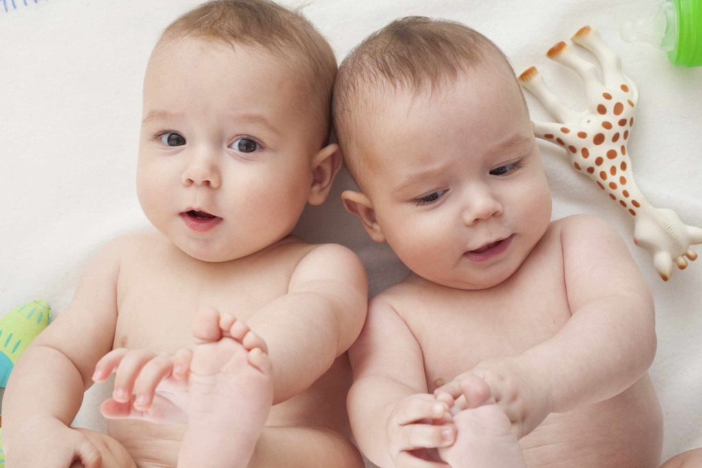 young twins are touching their little feet